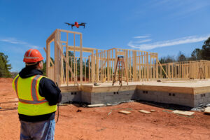 Inspector controls unfinished construction works of new house with help drone